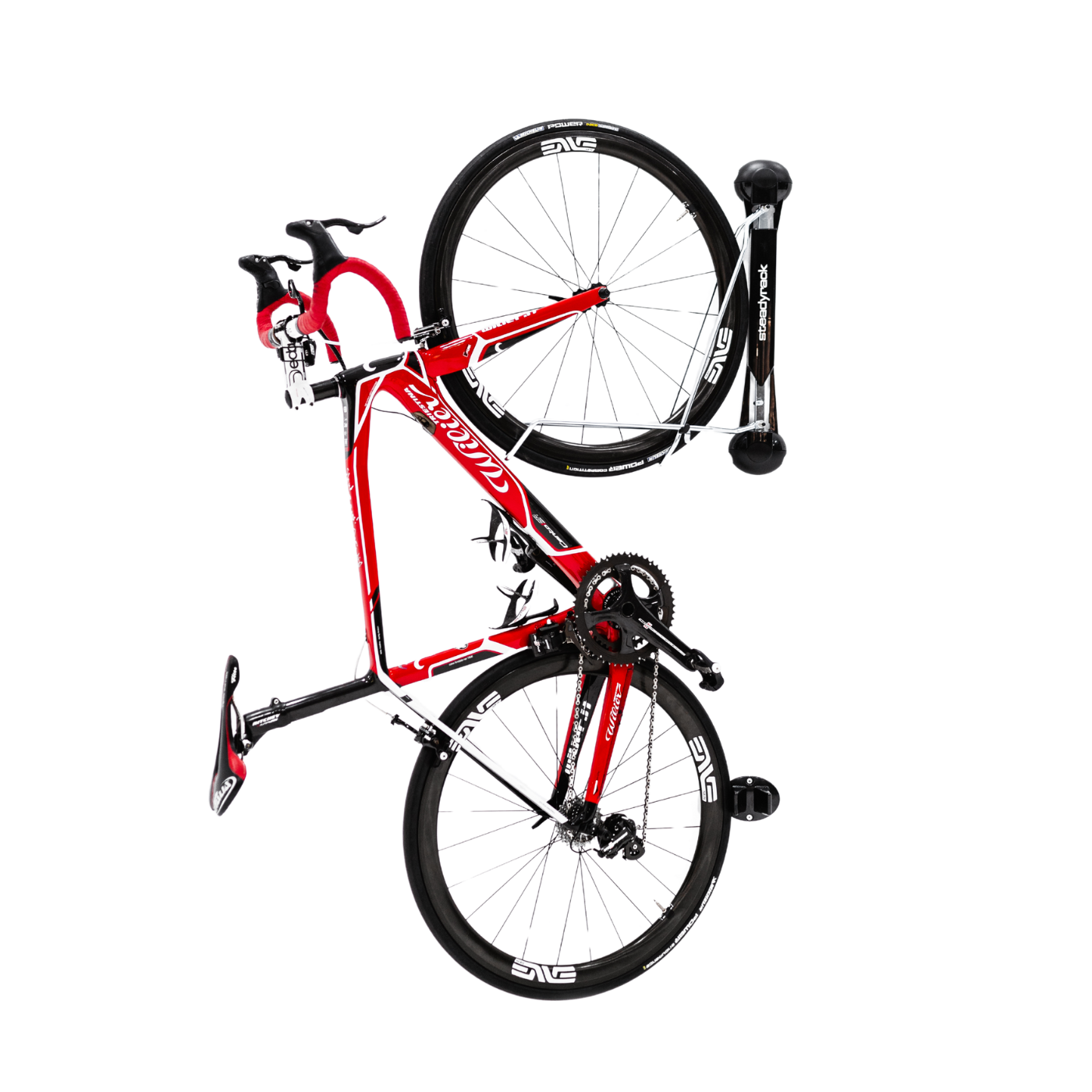 A black and red road bike stored in a classic road bike rack on a white background.