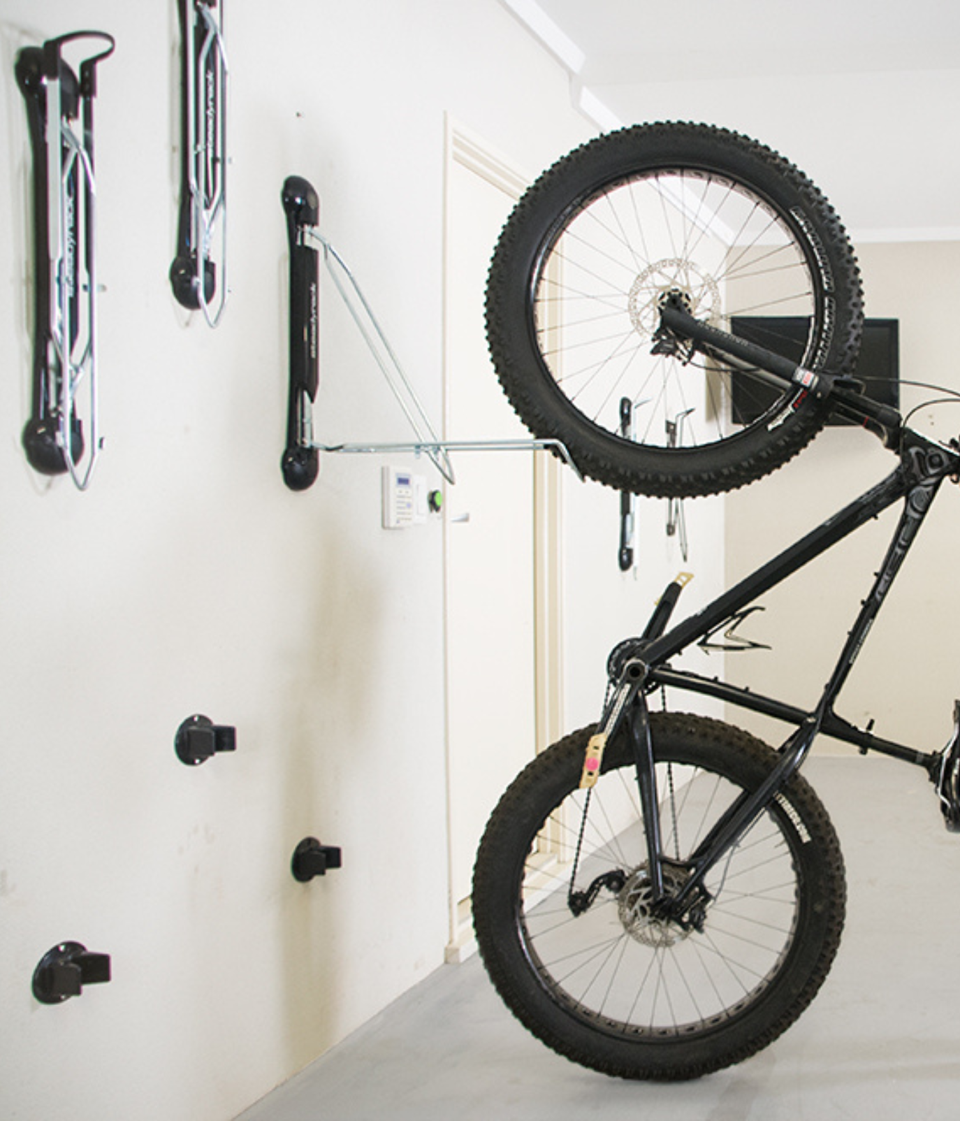A side shot of a fat bike being loaded into a Steadyrack bike rack in a garage.