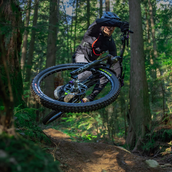 Person riding a mountain bike through a forest