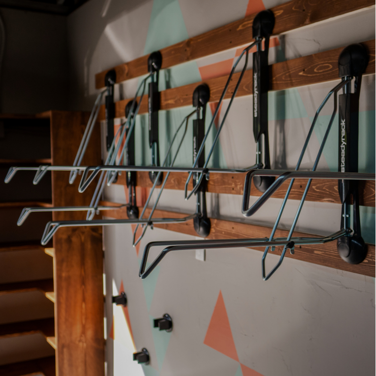 Wall-mounted bike rack on wooden panels.