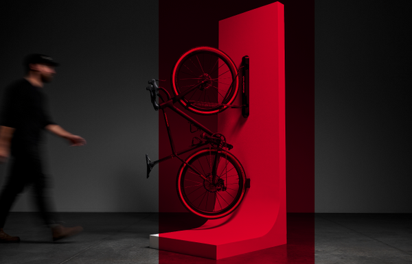 Bike on stand against a dark background with a person walking by